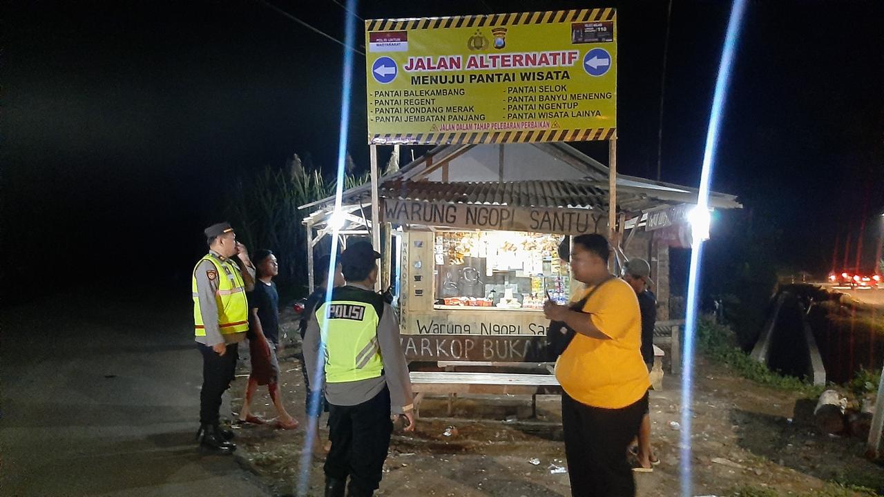 Petugas Kepolisian Polsek Bantur saat memasang banner dan rambu-rambu penunjuk arah di jalan menuju kawasan pantai di Malang Selatan (28/5/2025) (Dok. Humas Polres Malang)