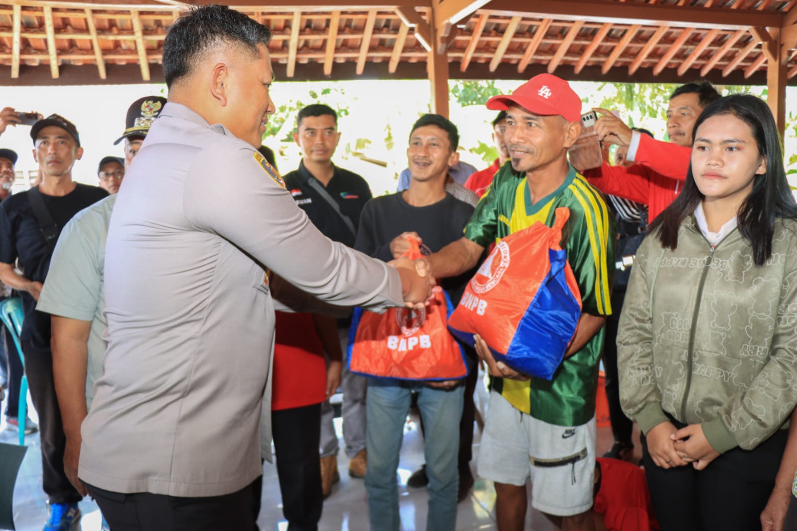 Bupati Malang HM Sanusi dan Kapolres Malang AKBP Danang Setiyo Pambudi Sukarno menyerahkan bantuan kepada warga terdampak banjir di Desa Sitiarjo, Minggu (21/9/2025). (Dok. Istimewa)