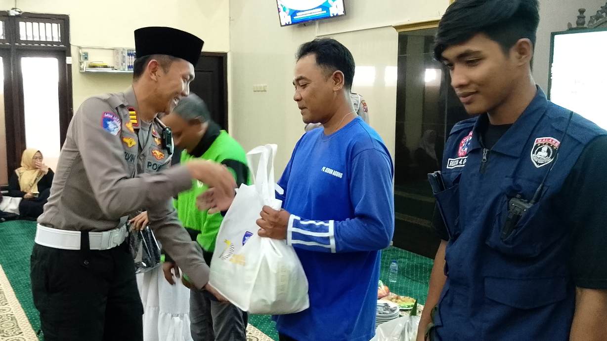 Kasatlantas Polres Malang, AKP. Muhammad Alif Chelvin Arlista, memberikan bingkisan kepada pengemudi ojol (19/9/2025) (foto: Abdullah/tagarjatim.id)
